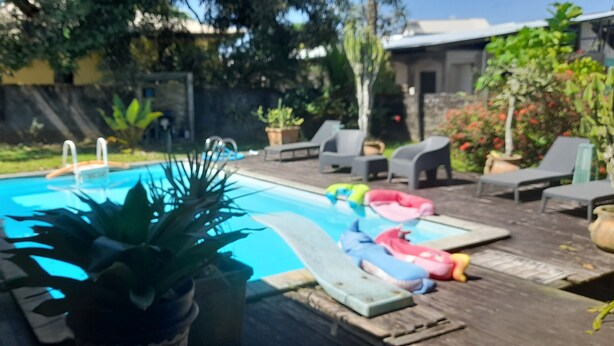 Ein Schwimmbecken mit Liegestühlen und aufblasbaren Spielzeugen.