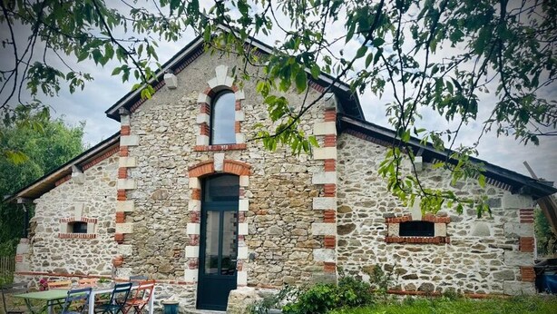 A stone building with a black door and a small window. - Chambre de Charme, Gîte de L'archerie (Saint-Lambert-la-Potherie)
