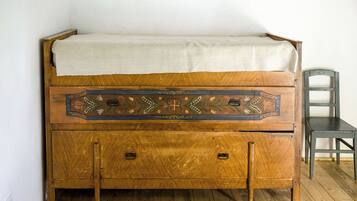 A wooden bed with a decorative headboard and a small chest of drawers below.