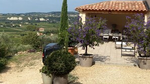 A patio with outdoor seating, a car, and a view of the countryside. - Studio in Seguret. Lisanathis (Seguret)