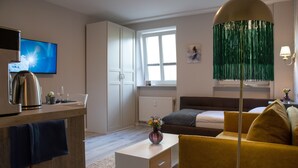 Een moderne woonkamer met een bank, een salontafel, een televisie en een lamp.