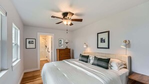 A bedroom with a bed, a ceiling fan, a bedside table, and a nightstand. - Wilbarger Villa-Sunsets Overlooking SWU & Downtown (Georgetown)