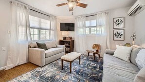A living room with a ceiling fan, a sofa, a coffee table, and a patterned rug.