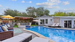 A swimming pool with lounge chairs and a covered seating area. - Your OASIS Nestled In Wooded River Views, POOL (Manchaca)