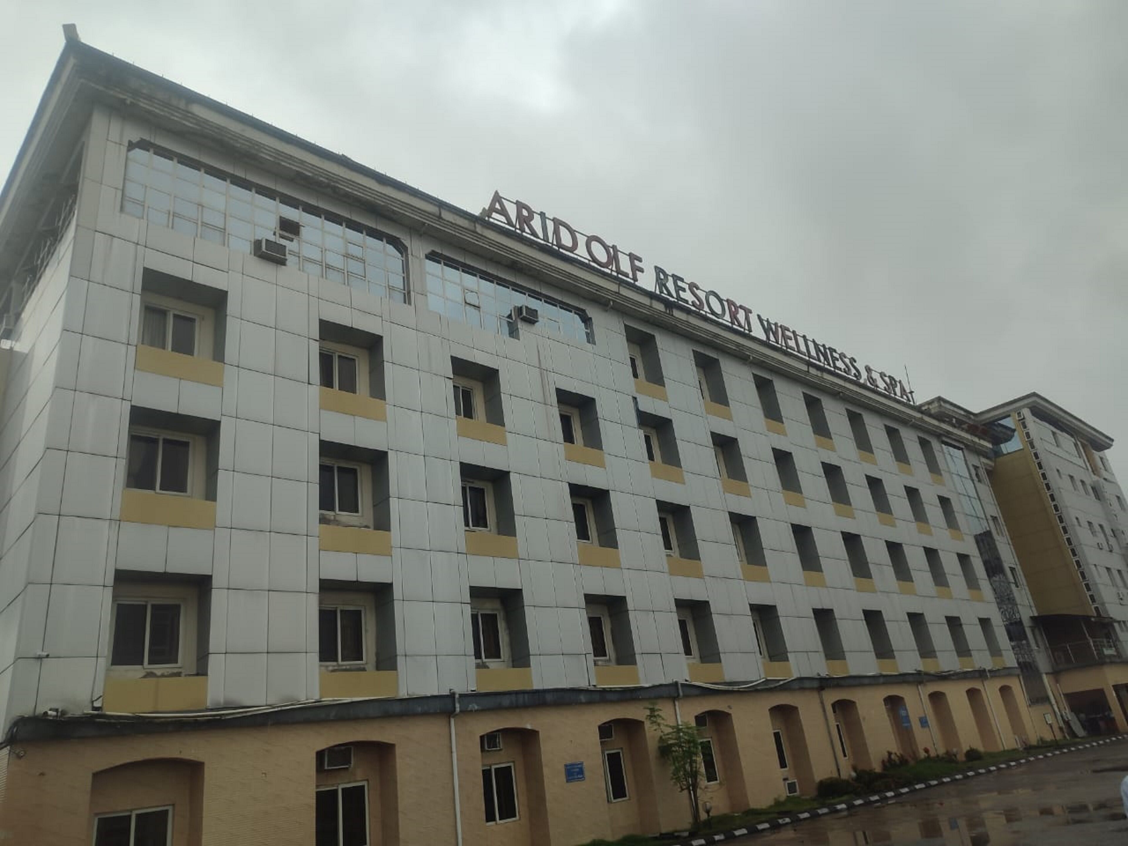 A multi-story building with a sign reading "ARIDO RESORT WELLNESS & SPA".