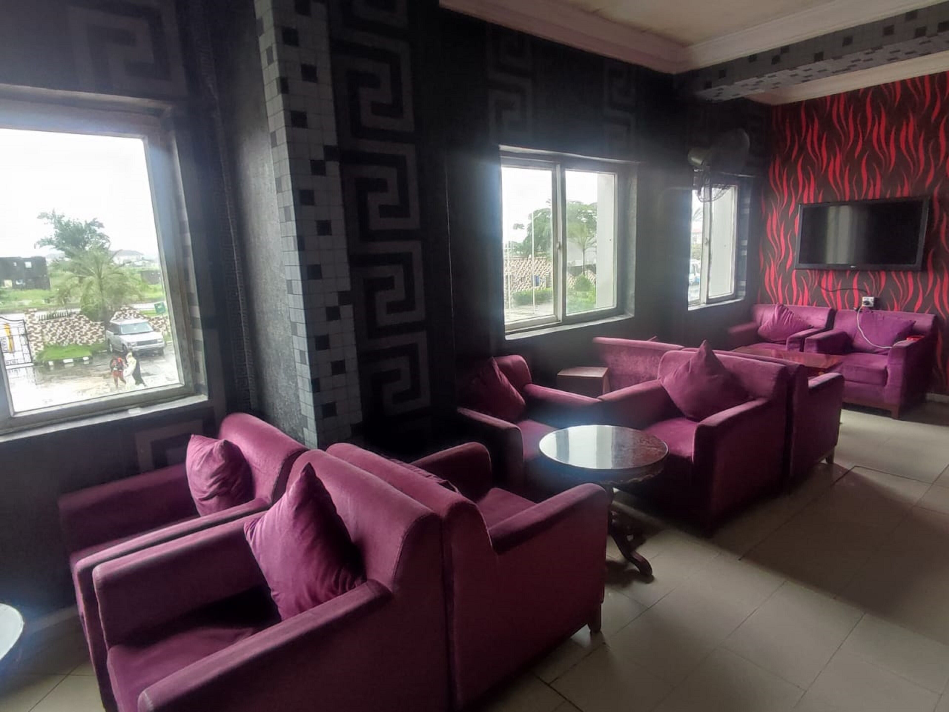 A modern lounge area with purple sofas and a flat-screen TV.