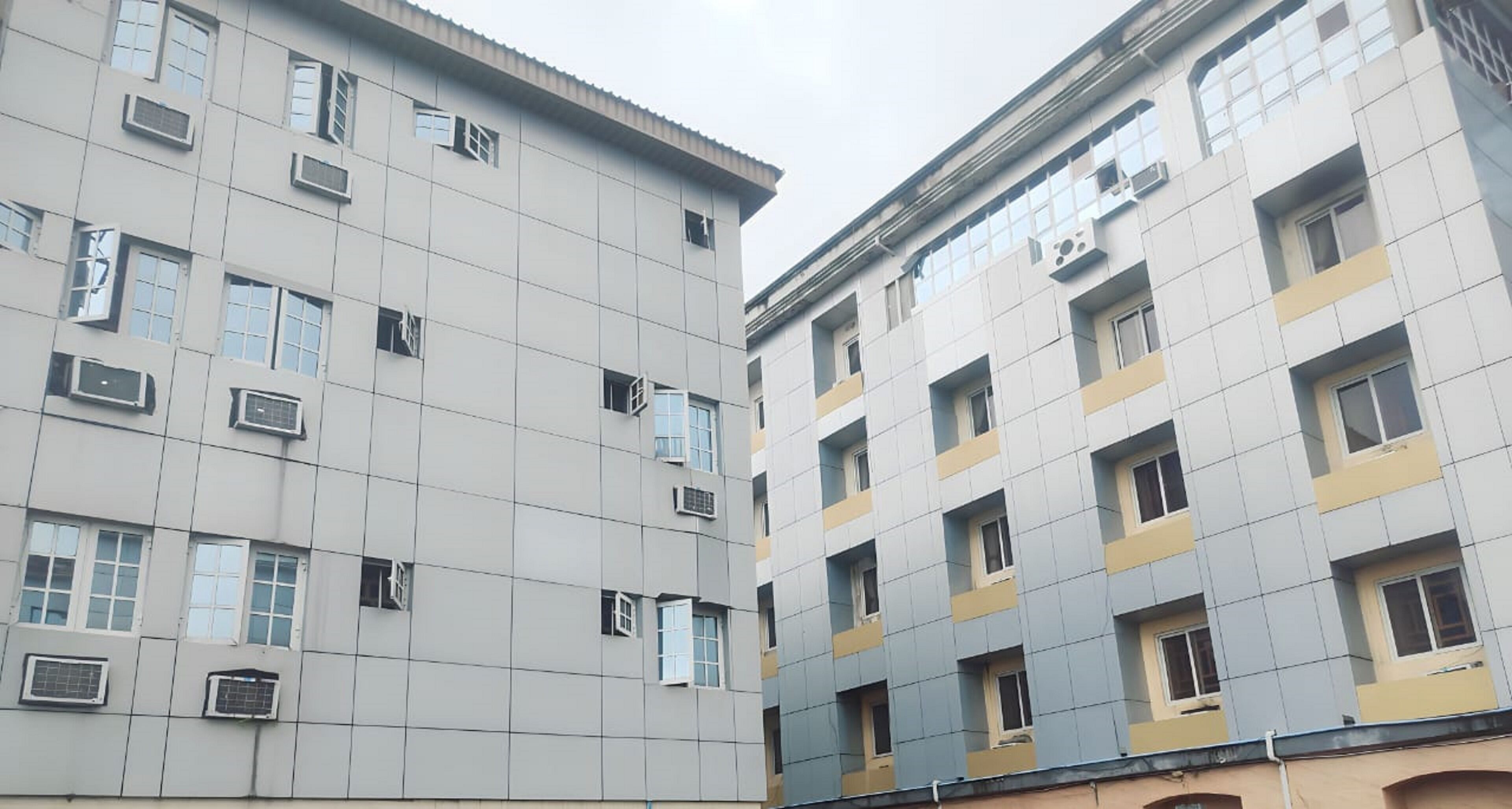 Un immeuble à plusieurs étages, doté d’une façade à motifs géométriques, de nombreuses fenêtres et de climatiseurs.