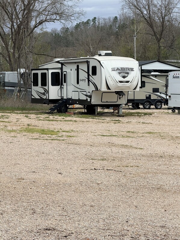 A Sabre RV with a compact layout, including a kitchenette and a sleeping area. - Current River Luxury in a Camper (Van Buren)