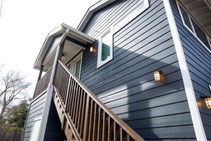 Stunning residential building with a grand staircase leading to a spacious balcony.