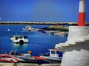Ein Hafen mit vertäuten Booten in der Nähe eines Leuchtturms.