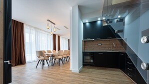 A modern kitchen with black cabinets, a wooden countertop, and a built-in oven.