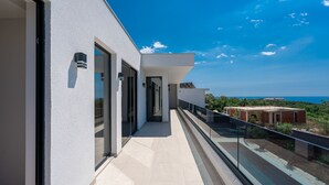 A modern building with a balcony overlooking a scenic view.