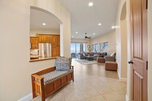 A spacious living area with a sofa, a coffee table, and a dining table. There is a kitchen with wooden cabinets and a refrigerator. - [The Ridgeview] 50 Mile Views (Page)