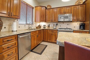 A kitchen with wooden cabinets, a stainless steel dishwasher, a microwave, and a stove. - [The Ridgeview] 50 Mile Views (Page)