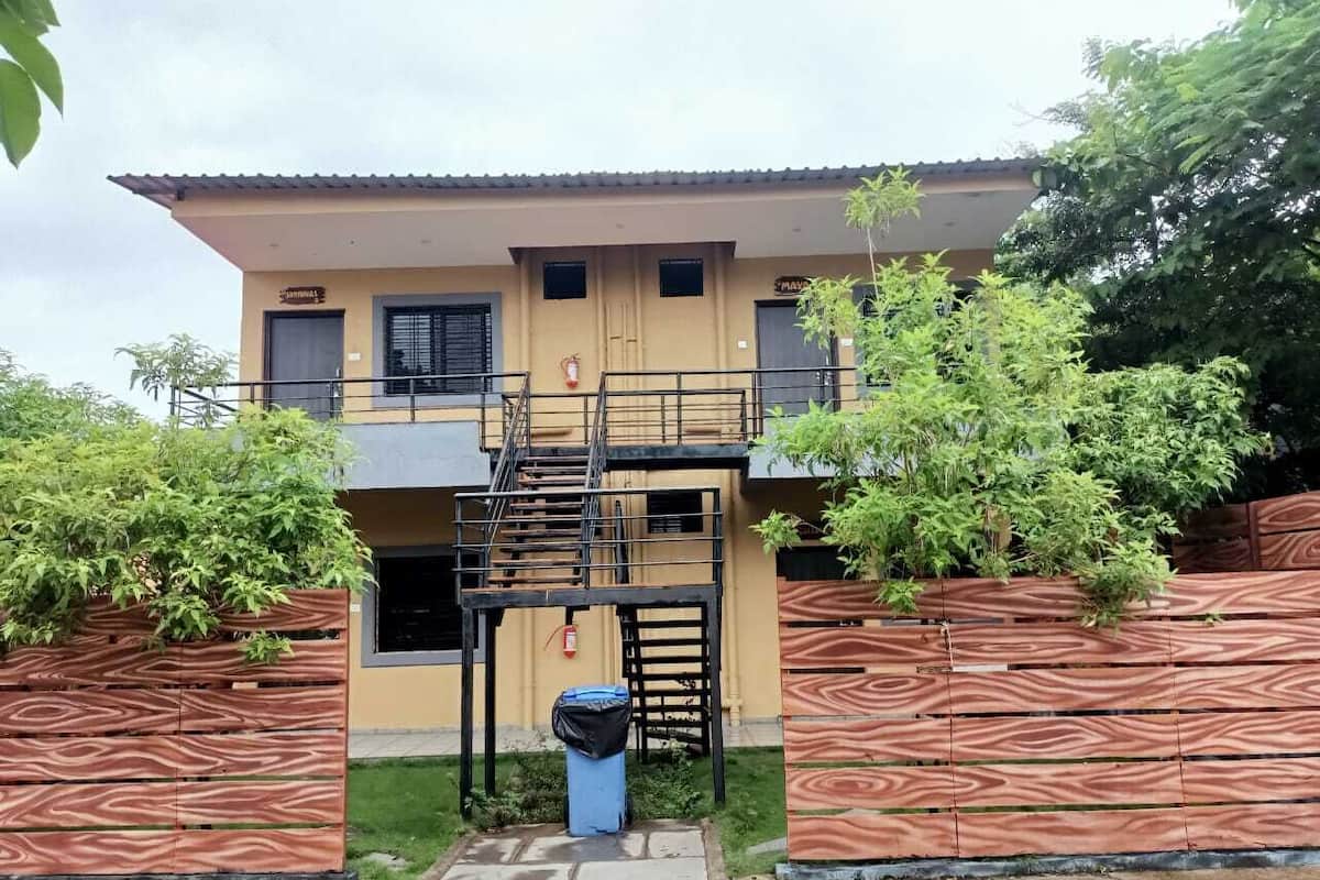 A two-story building with a balcony and a staircase leading to the upper floor.