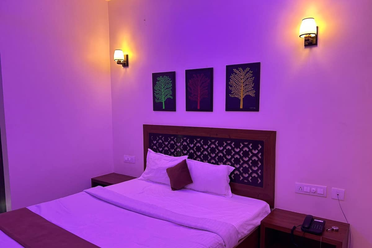 A room with a bed, nightstands, and wall-mounted light fixtures.