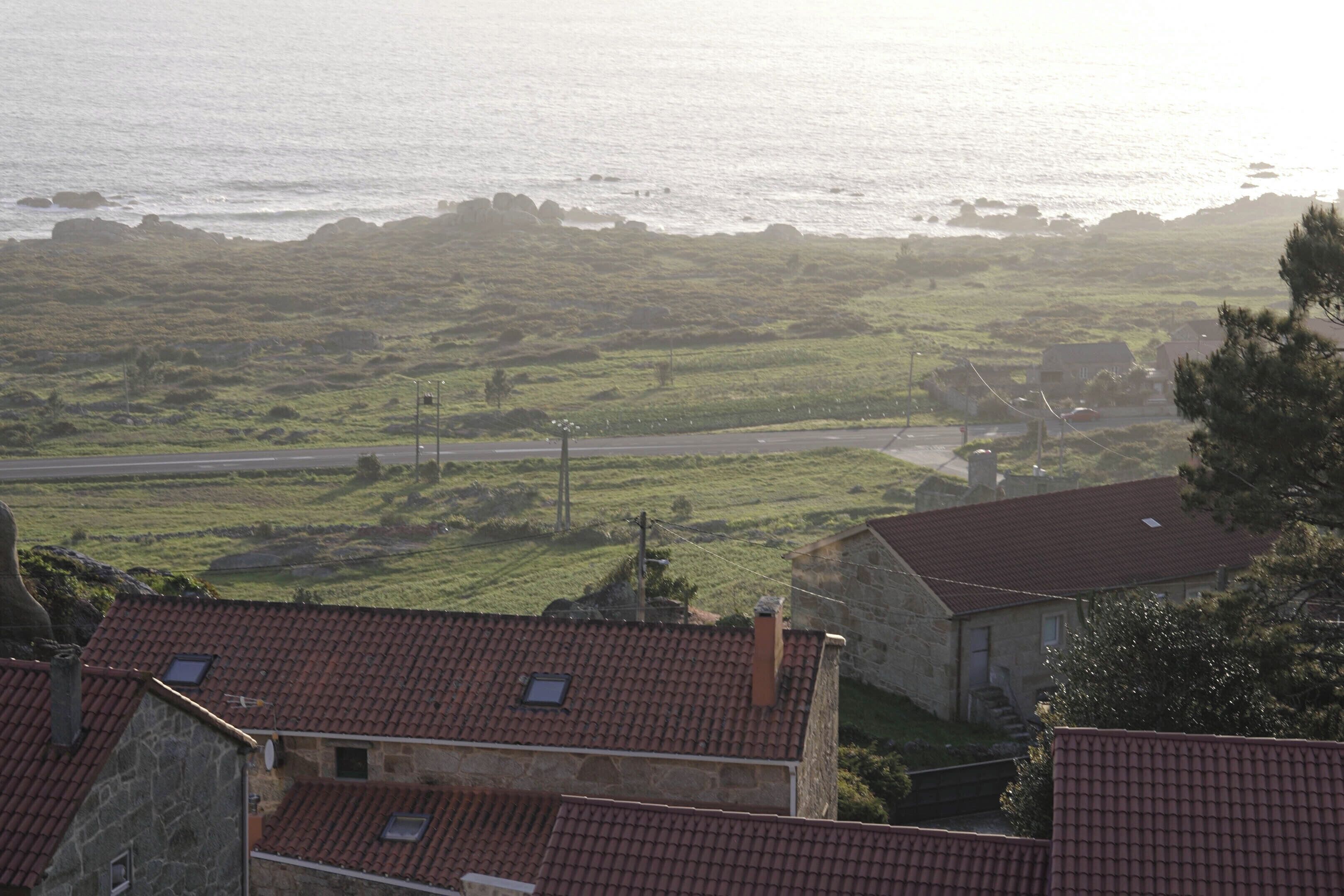 A coastal view with stone buildings and a road.