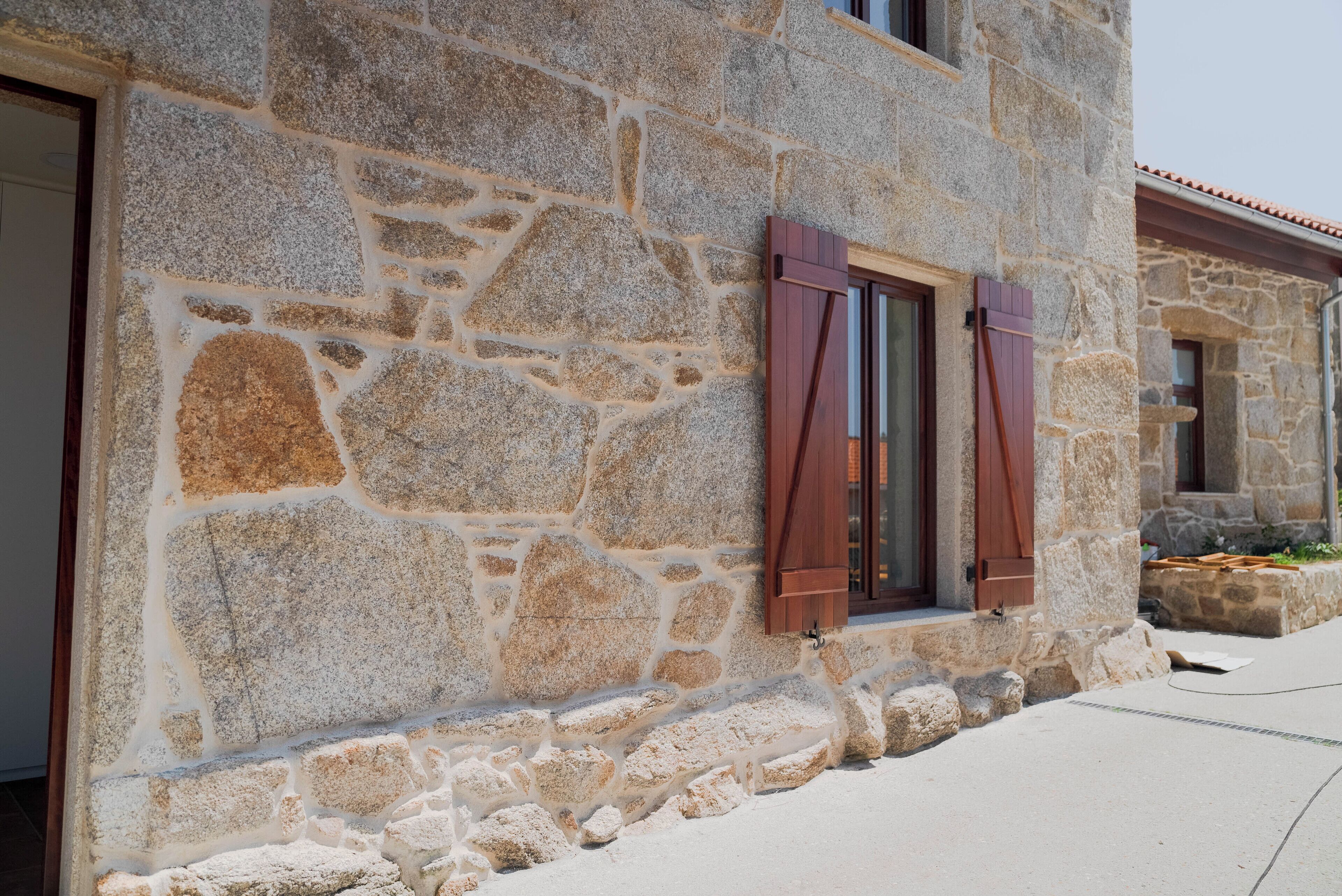 Un edificio de piedra con una ventana y una puerta.