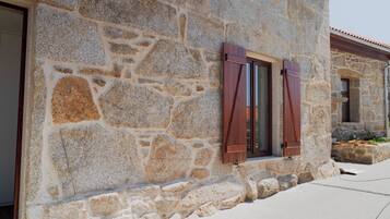 Un edificio de piedra con una ventana y una puerta.