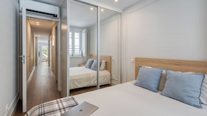A bedroom with a bed, a laptop, and a sliding door closet.