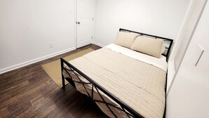 Ein Schlafzimmer mit einem Bett, einer Tür und Holzboden.