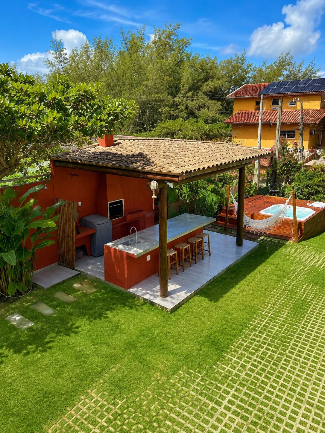 Un espace extérieur aménagé avec un barbecue, des sièges et un jacuzzi.