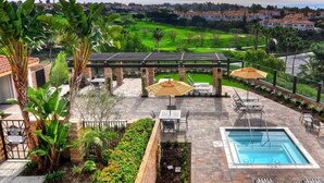 A pool area with a pool, lounge chairs, and a pergola.