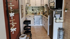 Una cucina compatta con isola centrale, forno a microonde e frigorifero.