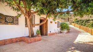 A patio with a table and chairs, a dartboard, and a tree. - Stunning home in Torrox (Torrox)