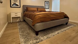 A bedroom with a bed, nightstands, a rug, and a ceiling light. - Centrally located home in the heart of Twin Falls.  (Twin Falls)