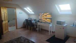 Ein gemütlicher Raum mit Essbereich, einer kleinen Küchenzeile und einem Oberlicht.