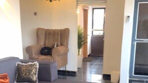 Una sala de estar moderna con un sofá gris, una mesa de centro negra y un sillón beige.