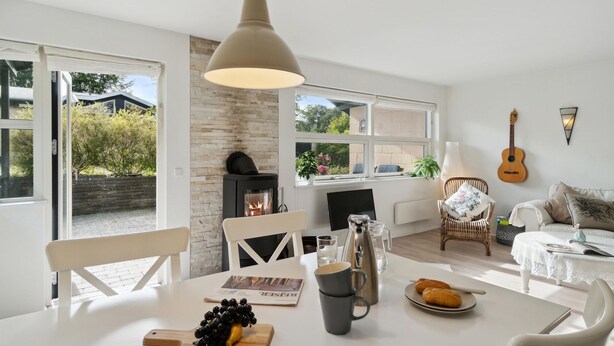A modern living room with a fireplace, dining table, and comfortable seating.