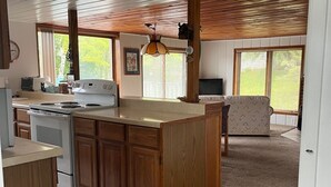 Una cocina amplia con armarios de madera, una isla central y un comedor con sofá.