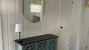 Un dormitorio con cama, cómoda, espejo y puerta.