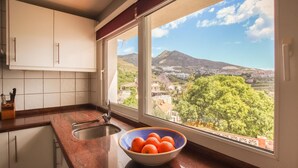 Una cocina con vista a una montaña y al pueblo.
