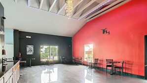 Een modern interieur met een rode accentmuur, een bar en zithoekjes.