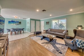 Relax in this spacious living area with a comfortable sofa and armchair, a dining table, and a patterned rug.