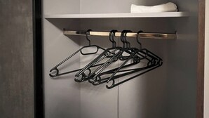A closet with a hanging rod and a shelf.