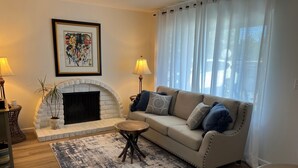 A living room with a fireplace, a sofa, a coffee table, and a rug. - Cozy townhome with backyard retreat! Minutes to wineries and downtown. (Livermore)