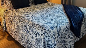 A bedroom with a bed, two pillows, a bedside lamp, a painting on the wall, and a window with curtains. - Cozy townhome with backyard retreat! Minutes to wineries and downtown. (Livermore)