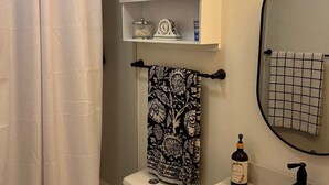 A bathroom with a toilet, a sink, a mirror, a towel rack, and a shower curtain. - Cozy townhome with backyard retreat! Minutes to wineries and downtown. (Livermore)