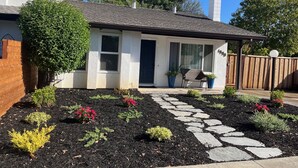 A single-story house with a covered porch, a stone pathway, and a variety of plants and shrubs. - Cozy townhome with backyard retreat! Minutes to wineries and downtown. (Livermore)