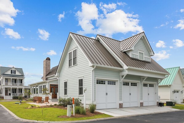 Une maison à deux étages avec un garage, un porche à l’avant et une pelouse bien entretenue.