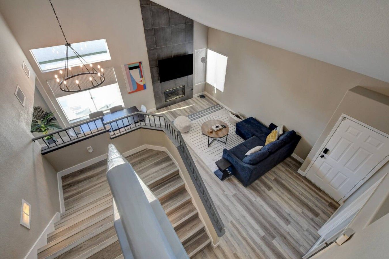 Un vaste espace de vie comprenant un escalier, un canapé, une table basse et une cheminée.
