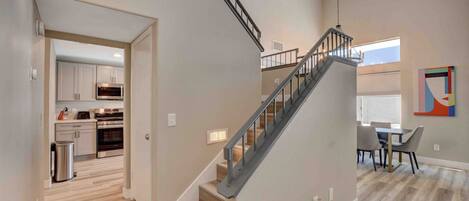 A modern interior with a staircase, a dining area, and a kitchen.