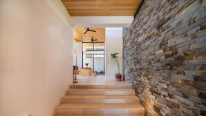 Una escalera con un muro de piedra a un lado y un techo de madera.