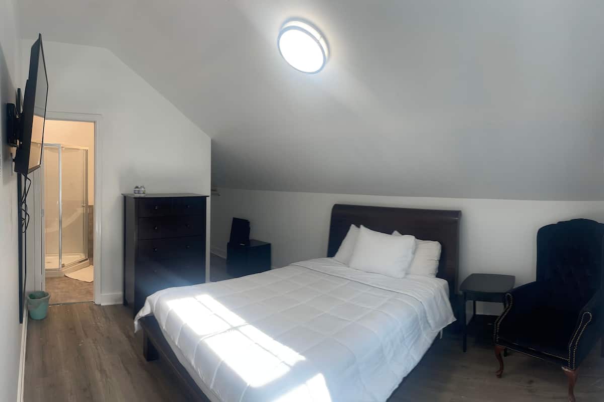 Une chambre à coucher avec un lit, une chaise, un bureau et une armoire.