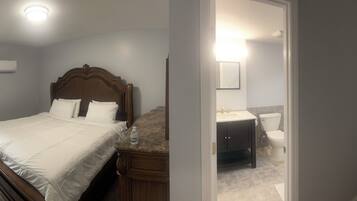 A bedroom with a bed, bedside table, and a mirror.
