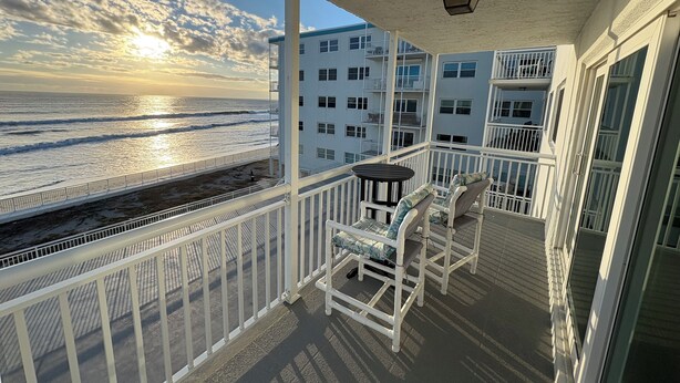 A balcony with a view of the ocean and a building in the background. - 1/1 Ocean View Condo at Sandpiper. Watch rocket launches from the balcony! (Satellite Beach)